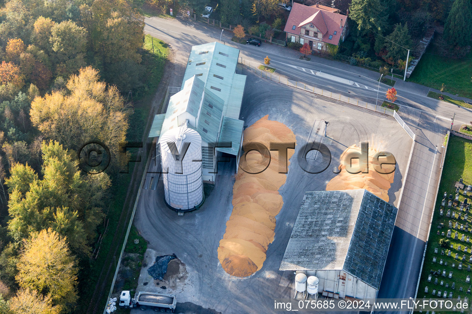 Vue aérienne de Montagnes de maïs dans la cour du silo et du magasin à grains avec entrepôts adjacents du Comptoir agricole - NIEDERROEDERN à Niederrœdern dans le département Bas Rhin, France