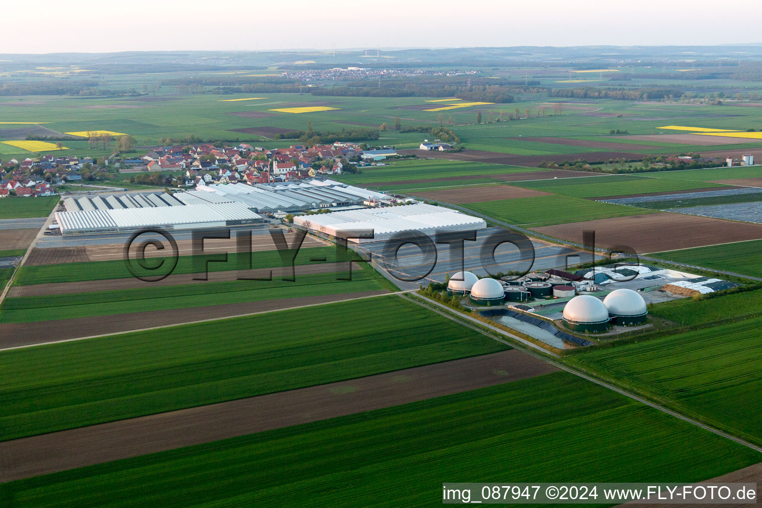 Vue aérienne de Toitures en verre dans les rangées de serres pour la floriculture et coupoles d'une installation de biogaz de Gartenbau Gernert à le quartier Oberspiesheim in Kolitzheim dans le département Bavière, Allemagne