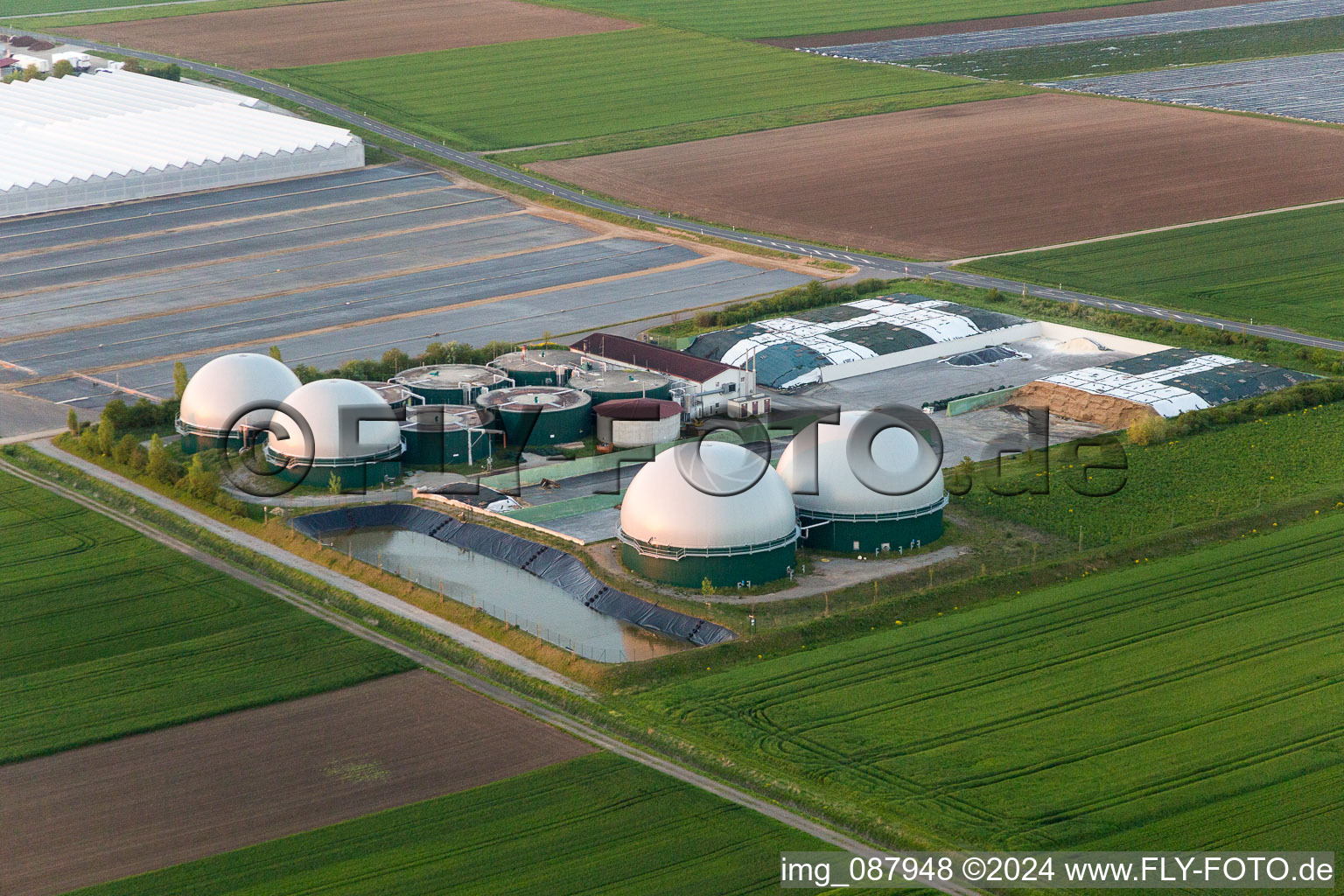 Vue aérienne de Toitures en verre dans les rangées de serres pour la floriculture et coupoles d'une installation de biogaz de Gartenbau Gernert à le quartier Oberspiesheim in Kolitzheim dans le département Bavière, Allemagne