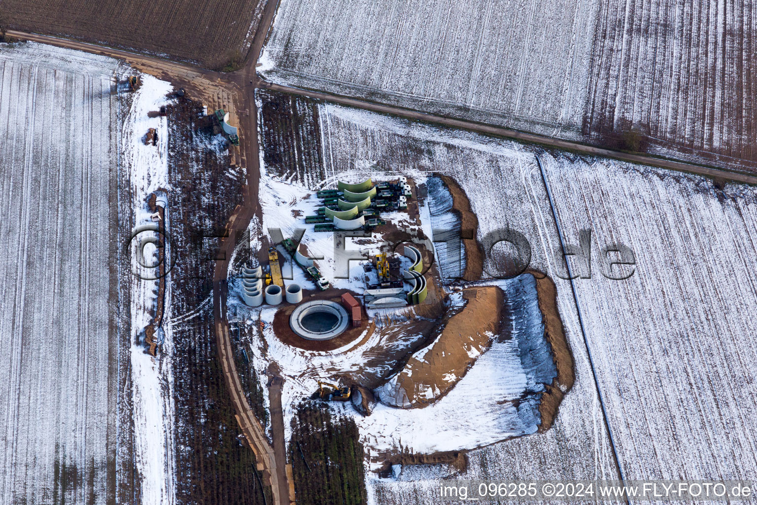 Vue oblique de Chantier de construction enneigé en hiver pour l'assemblage de la tour d'éolienne à Hatzenbühl dans le département Rhénanie-Palatinat, Allemagne