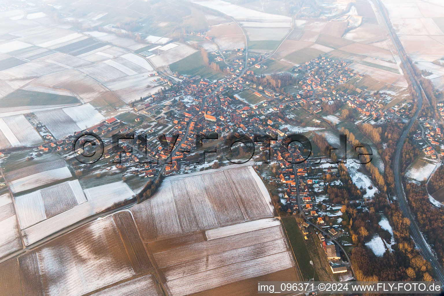 Vue aérienne de Champs agricoles et terres agricoles enneigés en hiver à Riedseltz dans le département Bas Rhin, France