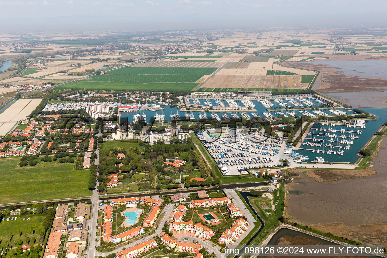 Vue aérienne de Marina avec amarrages pour bateaux de plaisance et postes d'amarrage sur la zone côtière de la Marina Punta Gabbiani Aprilia Marittima dans le quartier Aprilia Marittima de Bévazzana à le quartier Località Aprilia Marittima in Marano Lagunare dans le département Udine, Italie