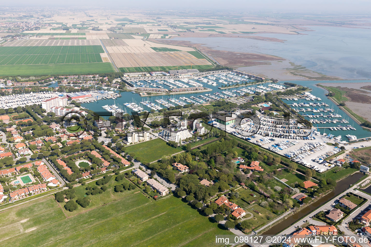 Vue aérienne de Marina avec amarrages pour bateaux de plaisance et postes d'amarrage sur la zone côtière de la Marina Punta Gabbiani Aprilia Marittima dans le quartier Aprilia Marittima de Bévazzana à le quartier Località Aprilia Marittima in Marano Lagunare dans le département Udine, Italie