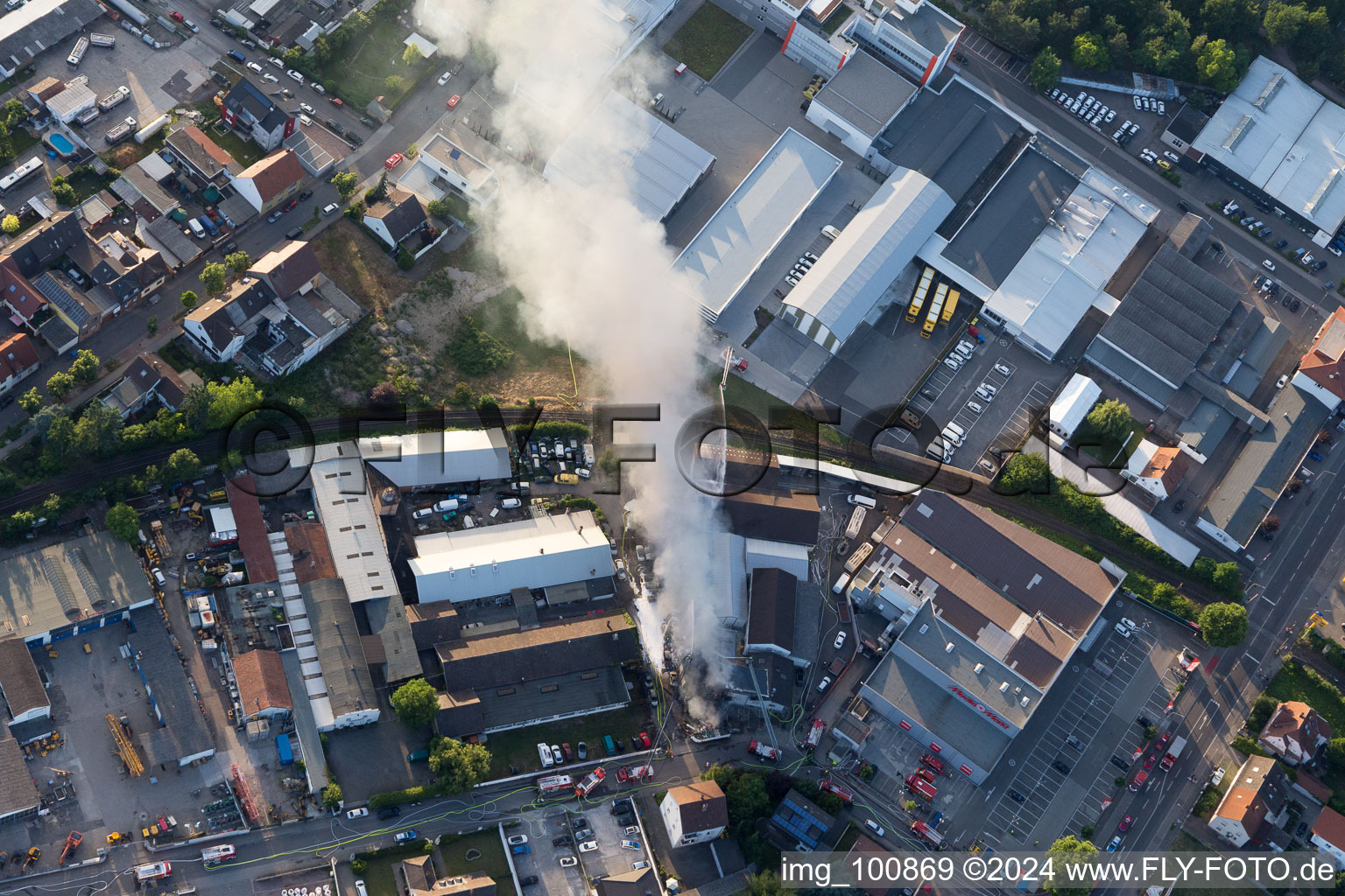 Formation de fumée et de flammes lors des travaux d'extinction d'un grand incendie dans un entrepôt d'antiquités et de vieilles voitures sur la Werkstrasse à Speyer dans le département Rhénanie-Palatinat, Allemagne hors des airs