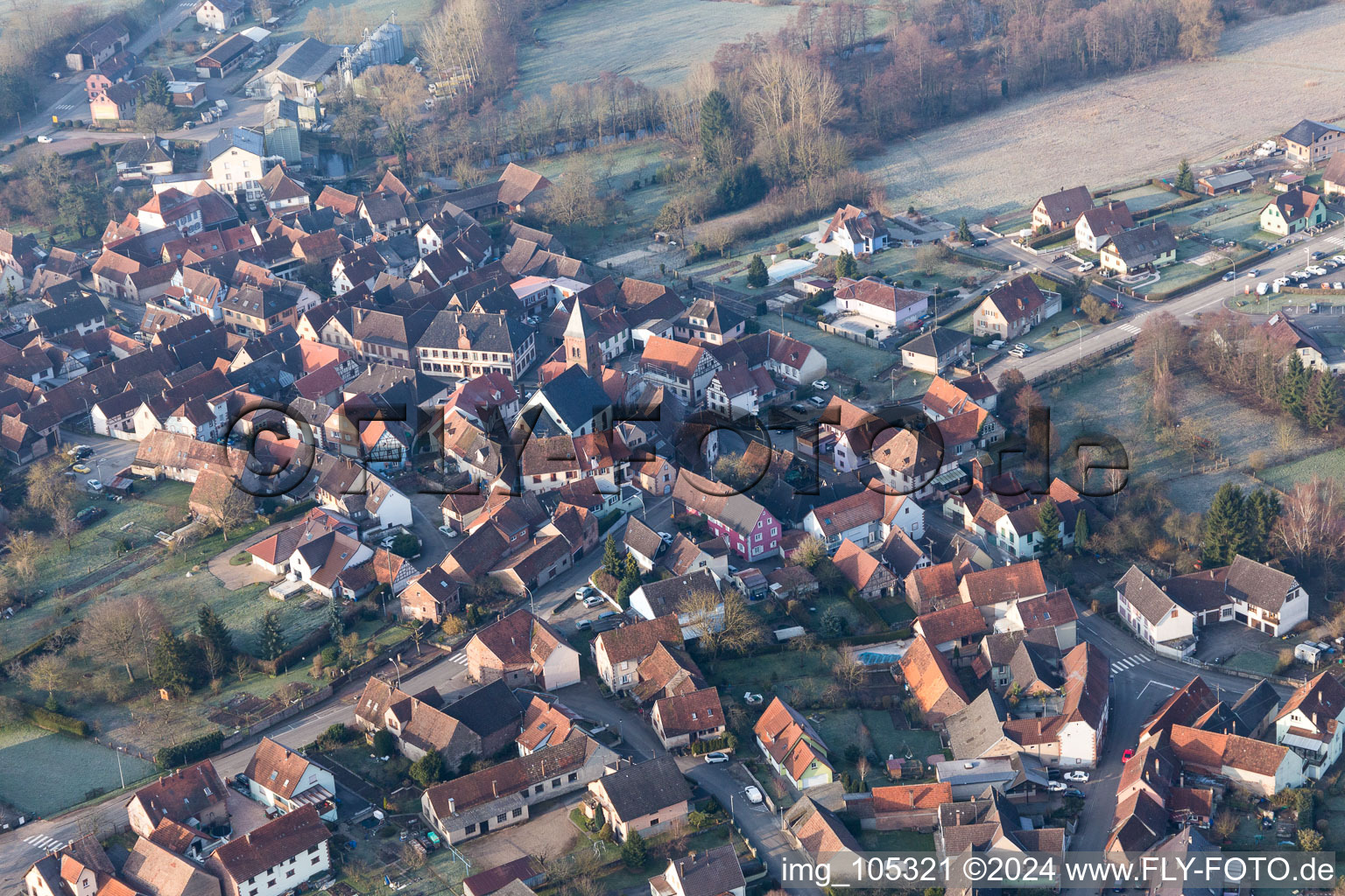 Vue aérienne de Église fortifiée luthérienne-protestante au centre du village entourée d'un anneau de maisons à Dossenheim-sur-Zinsel dans le département Bas Rhin, France
