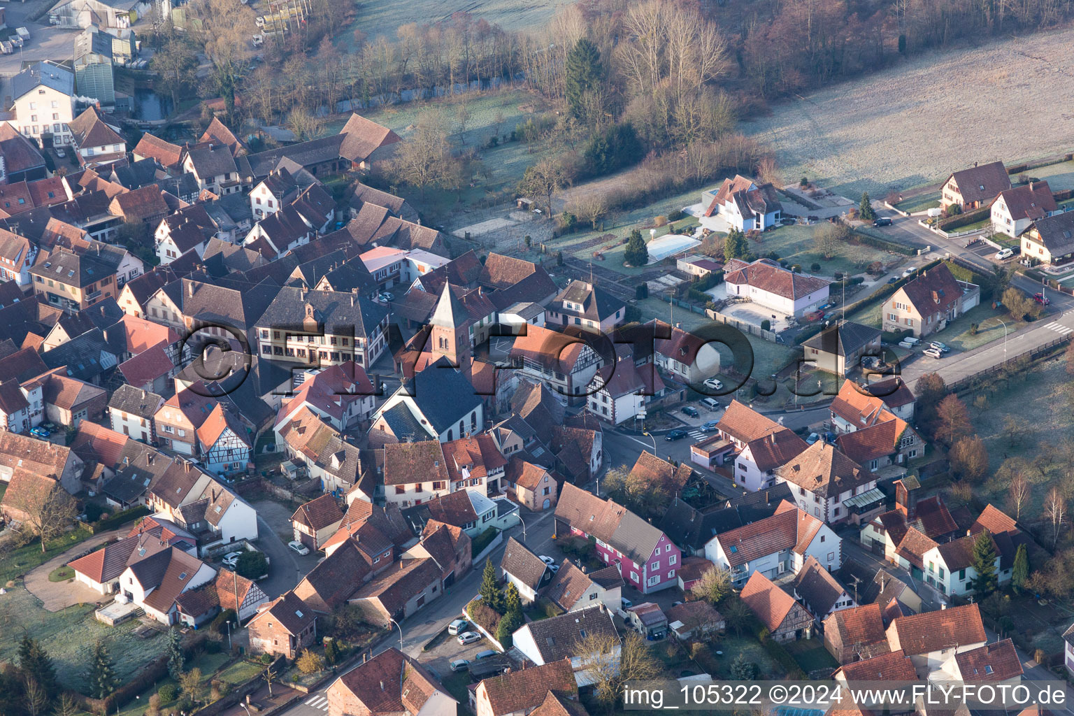 Vue aérienne de Église fortifiée luthérienne-protestante au centre du village entourée d'un anneau de maisons à Dossenheim-sur-Zinsel dans le département Bas Rhin, France
