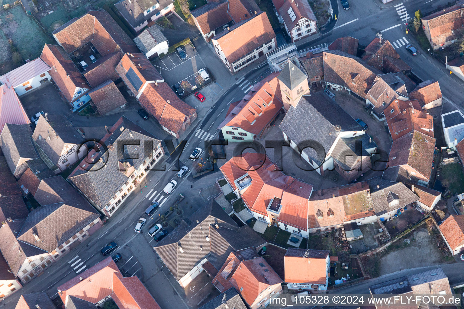 Église fortifiée luthérienne-protestante au centre du village entourée d'un anneau de maisons à Dossenheim-sur-Zinsel dans le département Bas Rhin, France vue d'en haut