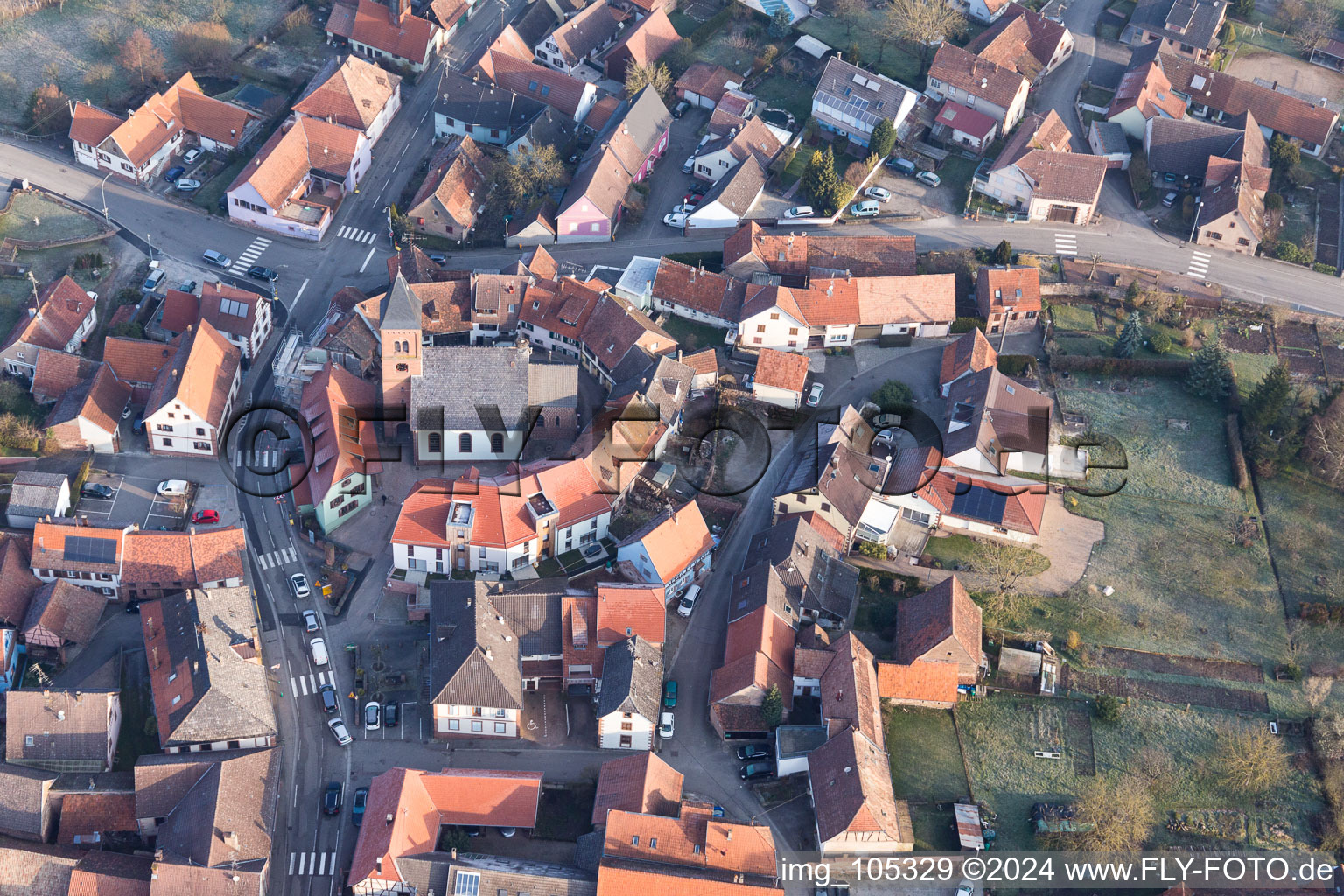 Église fortifiée luthérienne-protestante au centre du village entourée d'un anneau de maisons à Dossenheim-sur-Zinsel dans le département Bas Rhin, France depuis l'avion