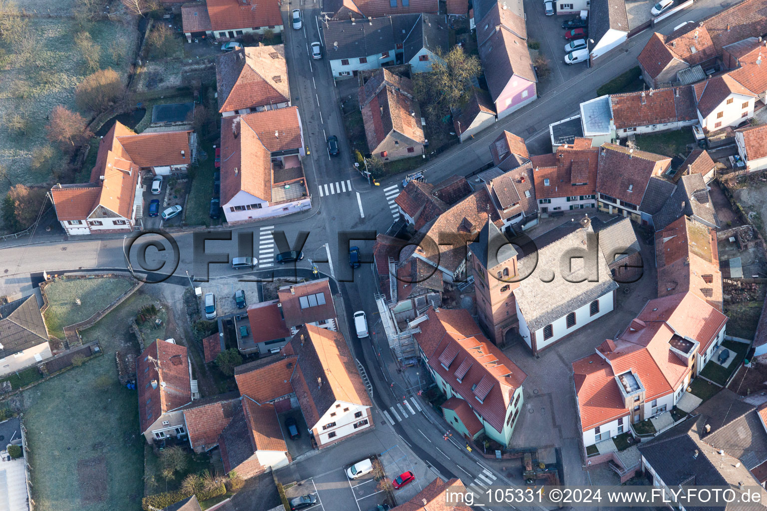 Église fortifiée luthérienne-protestante au centre du village entourée d'un anneau de maisons à Dossenheim-sur-Zinsel dans le département Bas Rhin, France vue du ciel