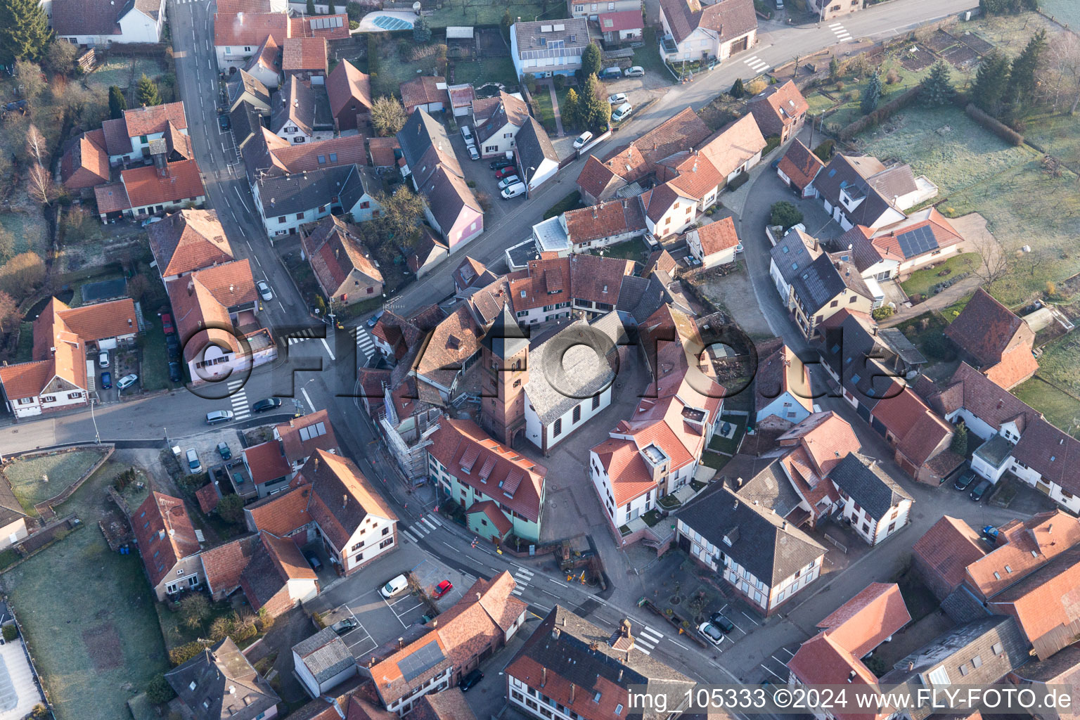 Image drone de Église fortifiée luthérienne-protestante au centre du village entourée d'un anneau de maisons à Dossenheim-sur-Zinsel dans le département Bas Rhin, France