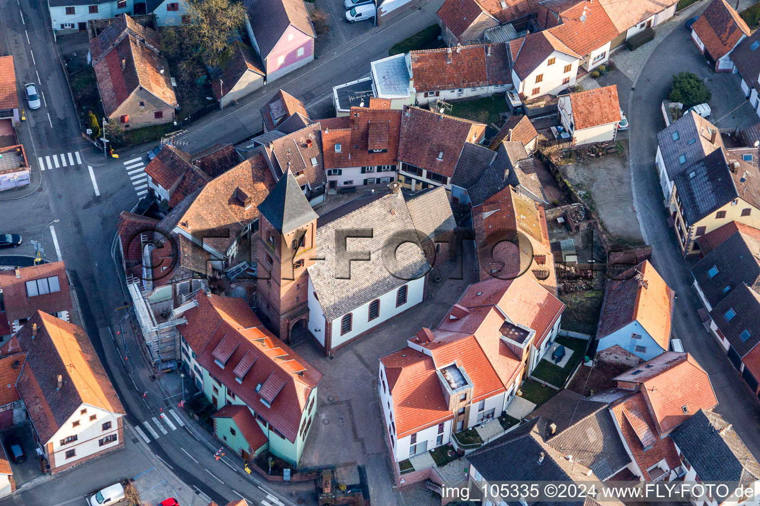 Vue aérienne de Église fortifiée protestante luthérienne de Saint-Léonhard entourée d'un anneau de maisons au centre du village à Dossenheim-sur-Zinsel dans le département Bas Rhin, France