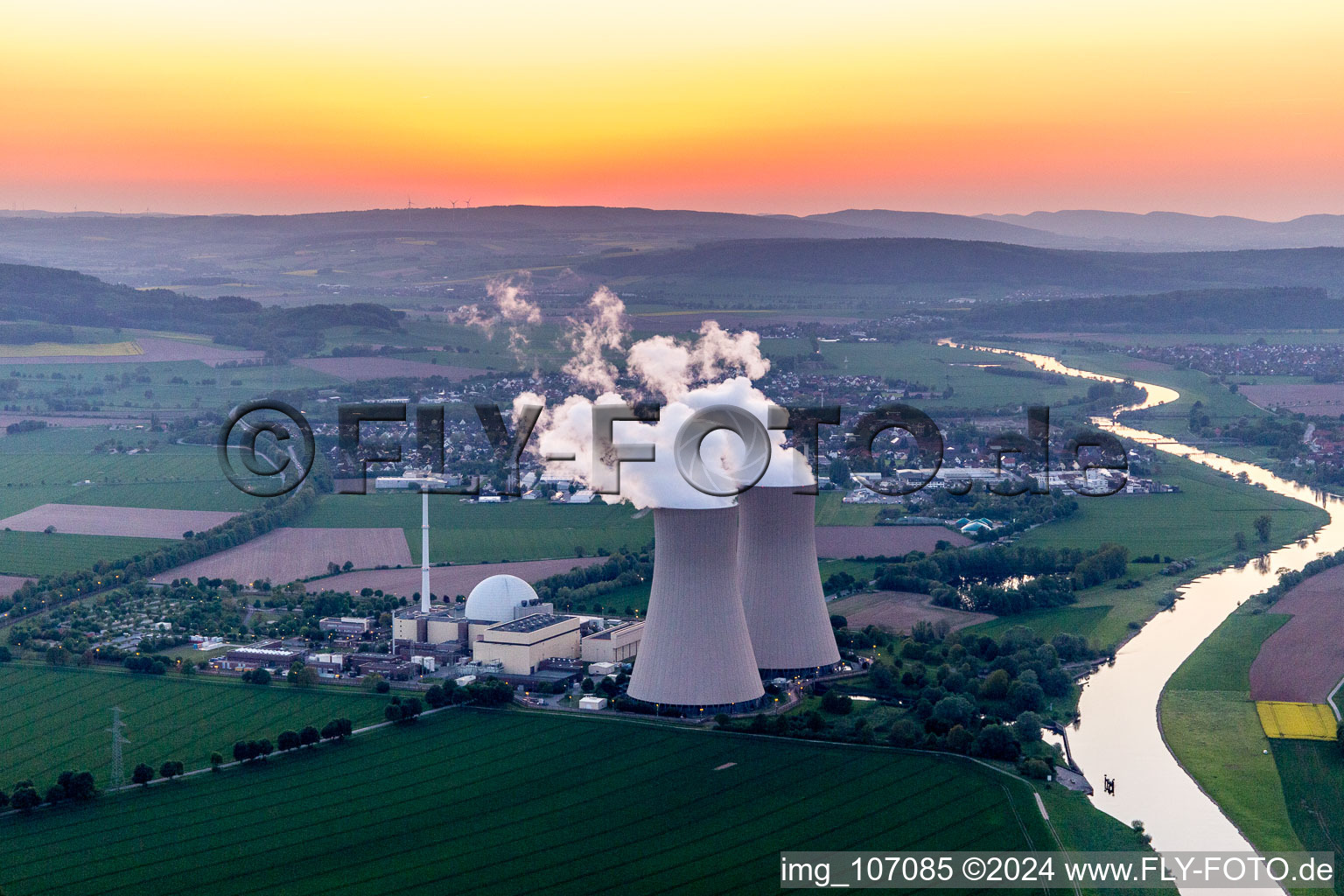 Vue aérienne de Blocs réacteurs, structures et systèmes de tour de refroidissement de la centrale nucléaire - centrale nucléaire - centrale nucléaire Grohnde sur la Weser au coucher du soleil en Grohnde à le quartier Grohnde in Emmerthal dans le département Basse-Saxe, Allemagne