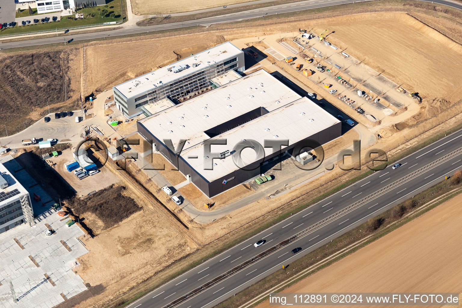 Vue aérienne de Nouveau bâtiment - chantier de construction des bâtiments et des halls de production de l'usine Eizo GmbH dans la zone industrielle nord à Rülzheim dans le département Rhénanie-Palatinat, Allemagne