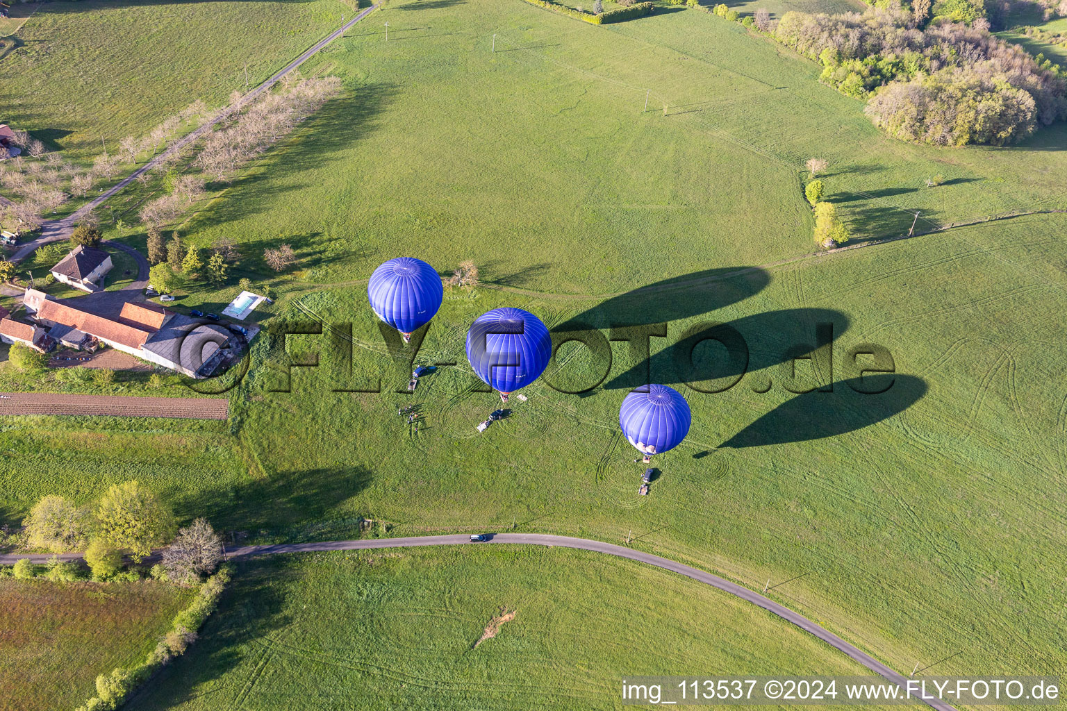 Vue aérienne de Trois montgolfières bleues décollant en Dordogne à Veyrines-de-Domme dans le département Dordogne, France