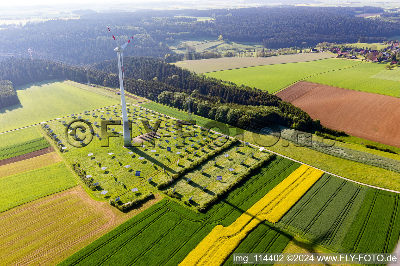 Vue aérienne de Éolienne (WEA) - éolienne - sur un champ de système solaire photovoltaïque à côté d'une ligne à haute tension à le quartier Römlinsdorf in Alpirsbach dans le département Bade-Wurtemberg, Allemagne