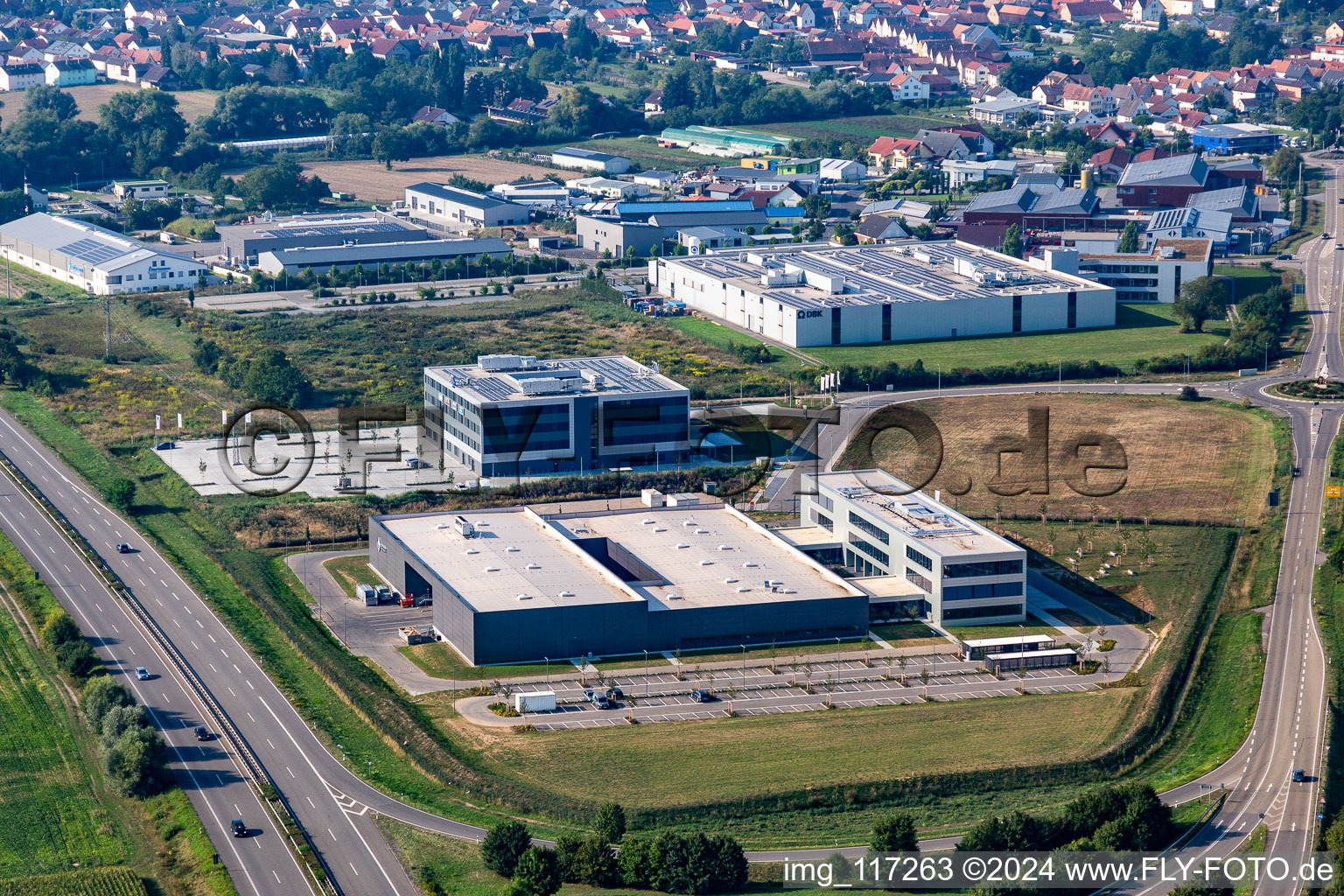 Photographie aérienne de Nouveau bâtiment - chantier de construction des bâtiments et des halls de production de l'usine Eizo GmbH dans la zone industrielle nord à Rülzheim dans le département Rhénanie-Palatinat, Allemagne