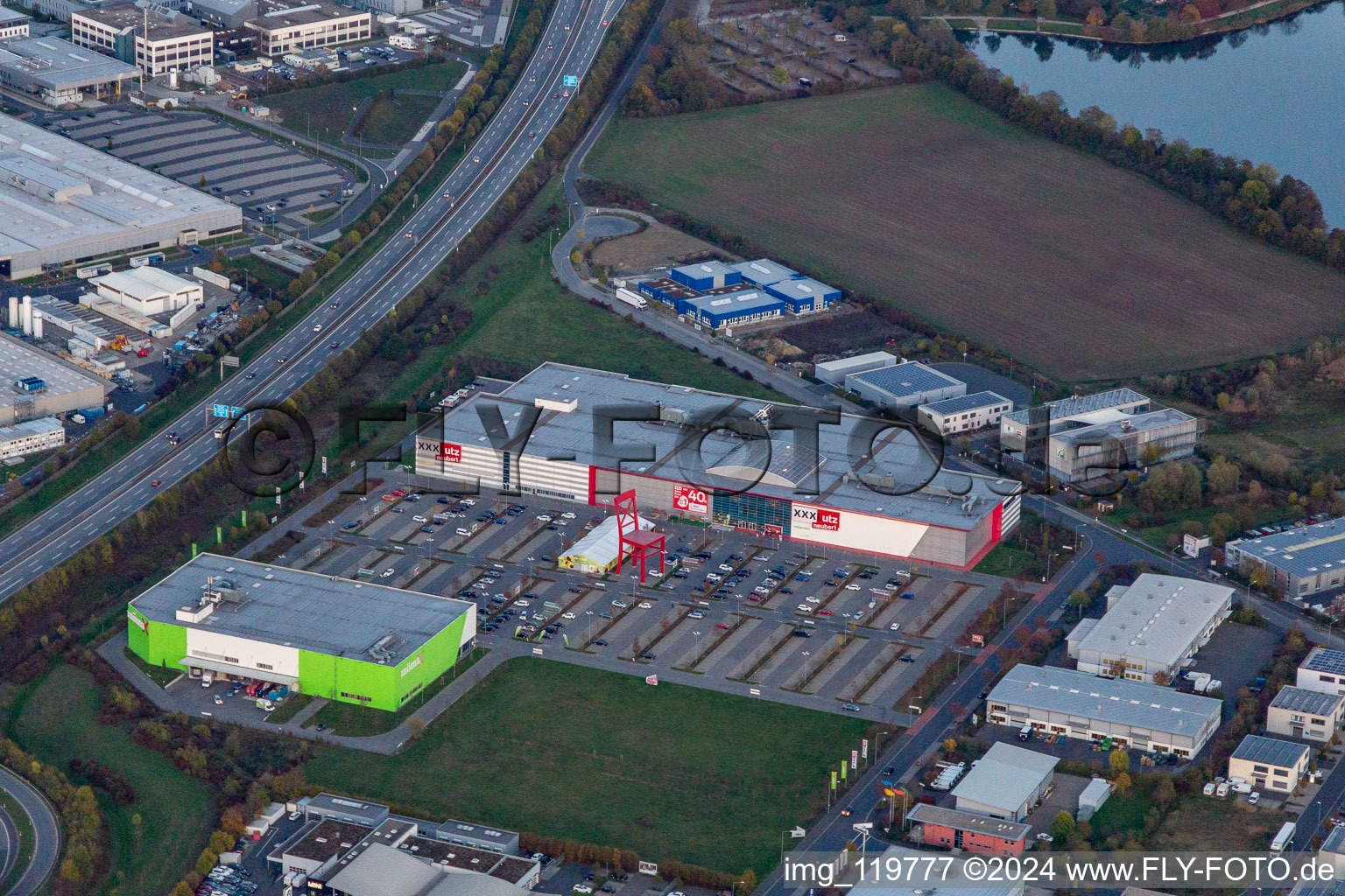 Vue aérienne de Chaise géante sur le parking du magasin de meubles - marché du meuble XXXLutz Neubert Schweinfurt dans l'espace textile de Maintal à le quartier Oberndorf in Schweinfurt dans le département Bavière, Allemagne