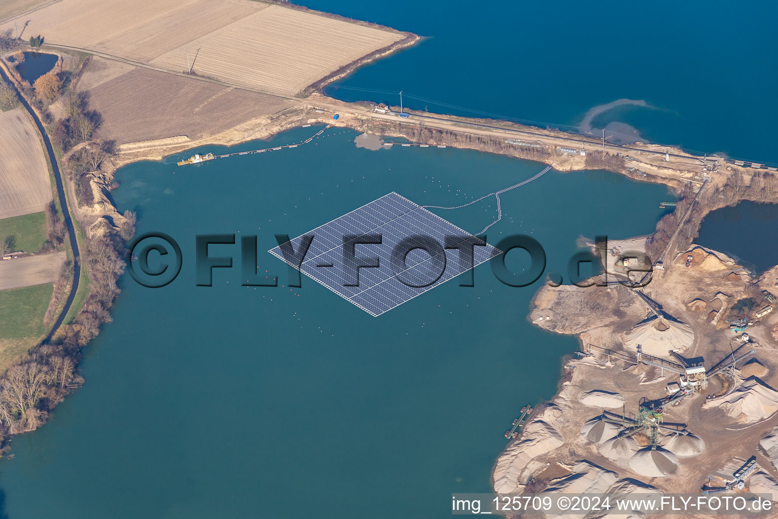 Vue aérienne de Centrale solaire flottante et champs de panneaux de systèmes photovoltaïques à la surface de l'eau sur un lac de carrière pour l'extraction de gravier à Leimersheim dans le département Rhénanie-Palatinat, Allemagne