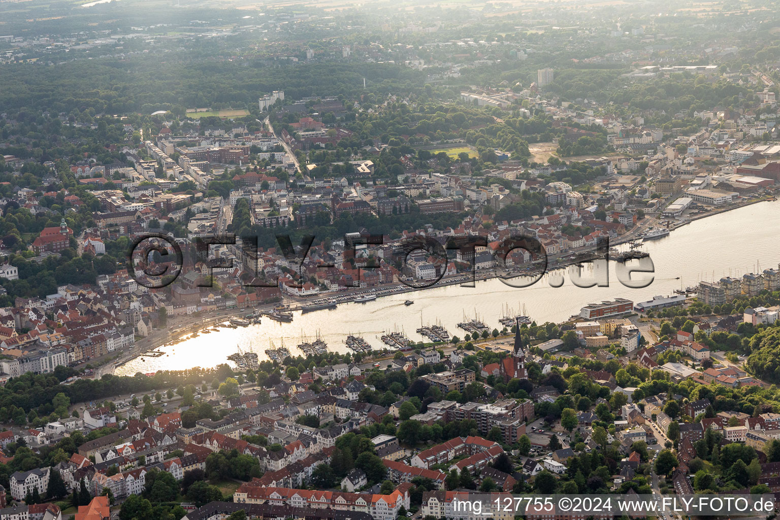 Vue aérienne de Marina avec amarres pour bateaux de plaisance et amarres pour bateaux sur la zone riveraine de la pointe du port. Un bateau d'excursion se dirige vers son poste d'amarrage sur la rive ouest. A proximité immédiate des ponts et jetées de l'association « Port Historique Flensburg ». En face sur la rive est : le port de la ville et un petit club de pêche à le quartier Kielseng in Flensburg dans le département Schleswig-Holstein, Allemagne