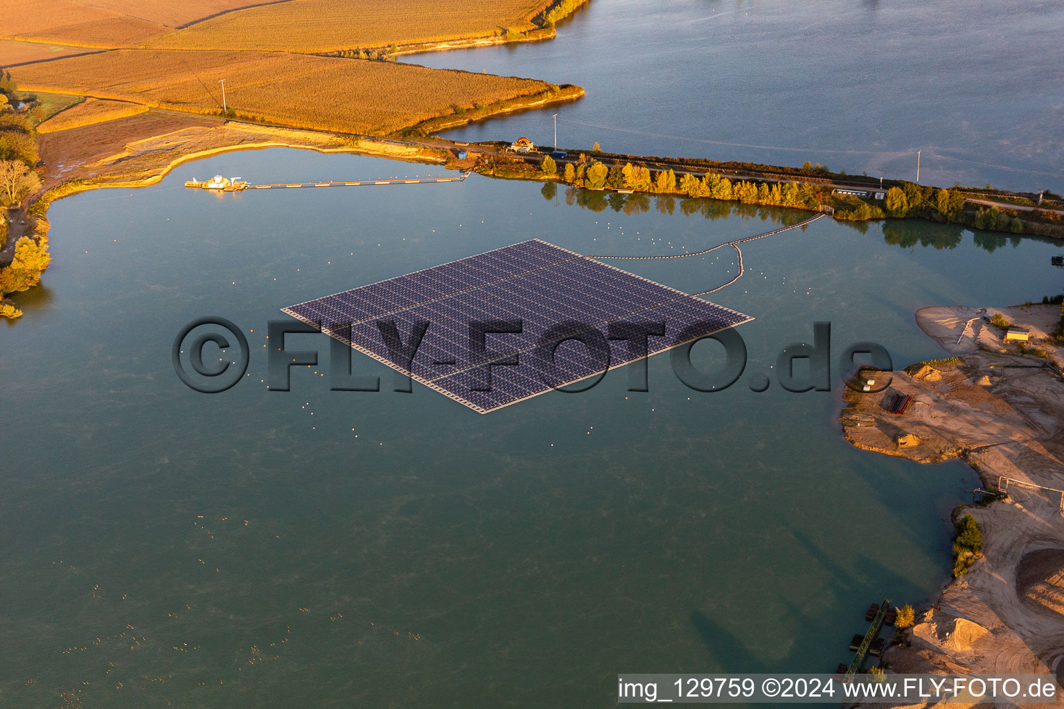 Vue oblique de Centrale solaire flottante et champs de panneaux de systèmes photovoltaïques à la surface de l'eau sur un lac de carrière pour l'extraction de gravier à Leimersheim dans le département Rhénanie-Palatinat, Allemagne