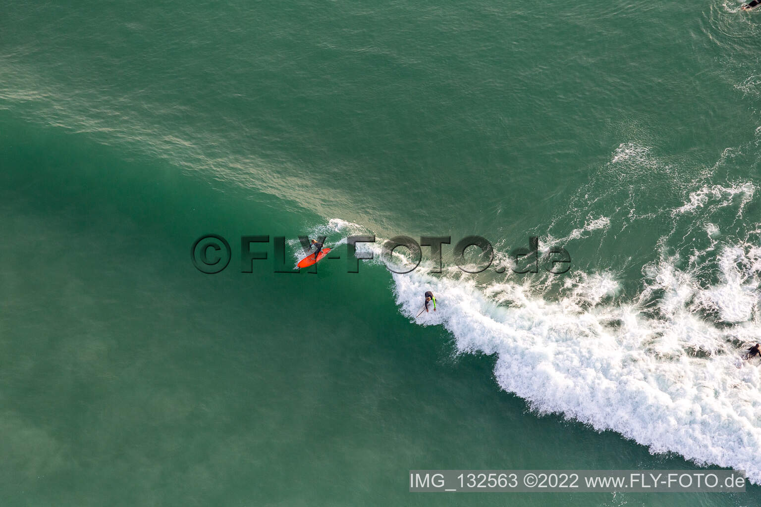 Wave surfeurs devant la Plage de Tronoën à Saint-Jean-Trolimon dans le département Finistère, France vue du ciel