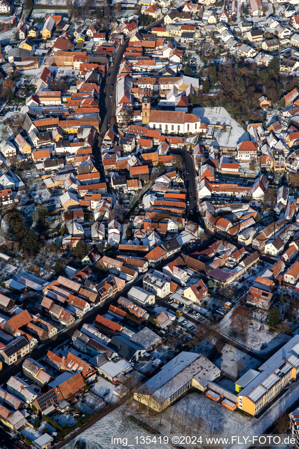 Vue oblique de Rue principale avec l'église paroissiale de Saint-Michel en hiver avec de la neige à Rheinzabern dans le département Rhénanie-Palatinat, Allemagne