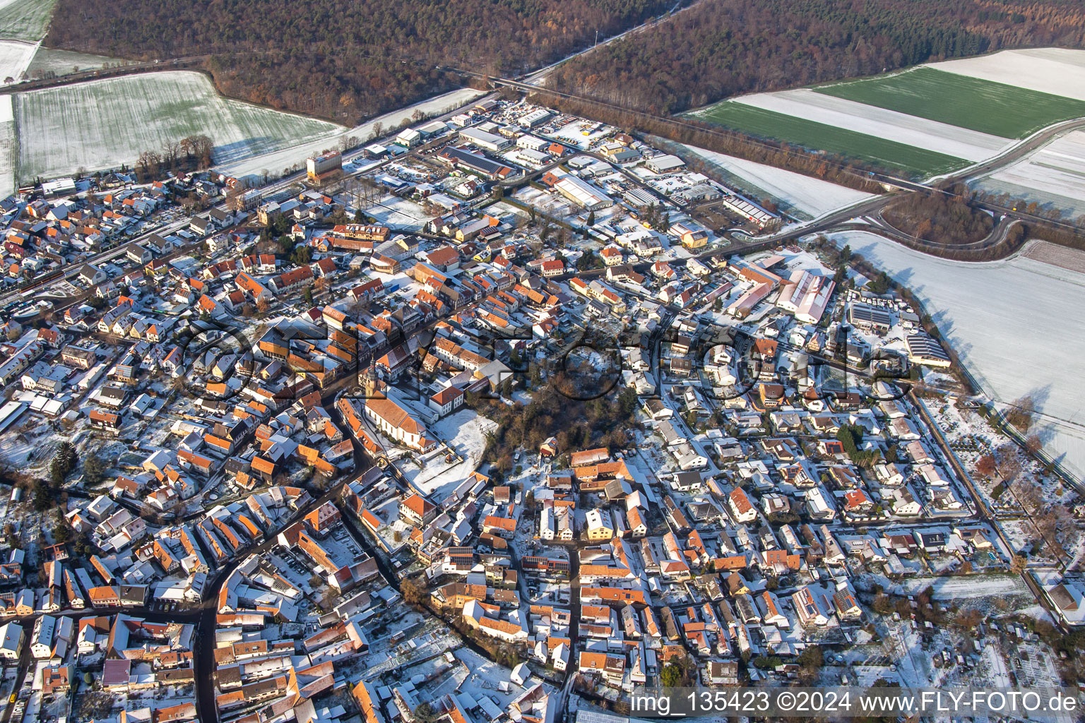 Rue principale avec l'église paroissiale de Saint-Michel en hiver avec de la neige à Rheinzabern dans le département Rhénanie-Palatinat, Allemagne vue d'en haut