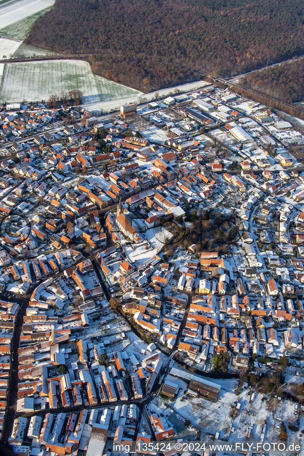 Rue principale avec l'église paroissiale de Saint-Michel en hiver avec de la neige à Rheinzabern dans le département Rhénanie-Palatinat, Allemagne depuis l'avion