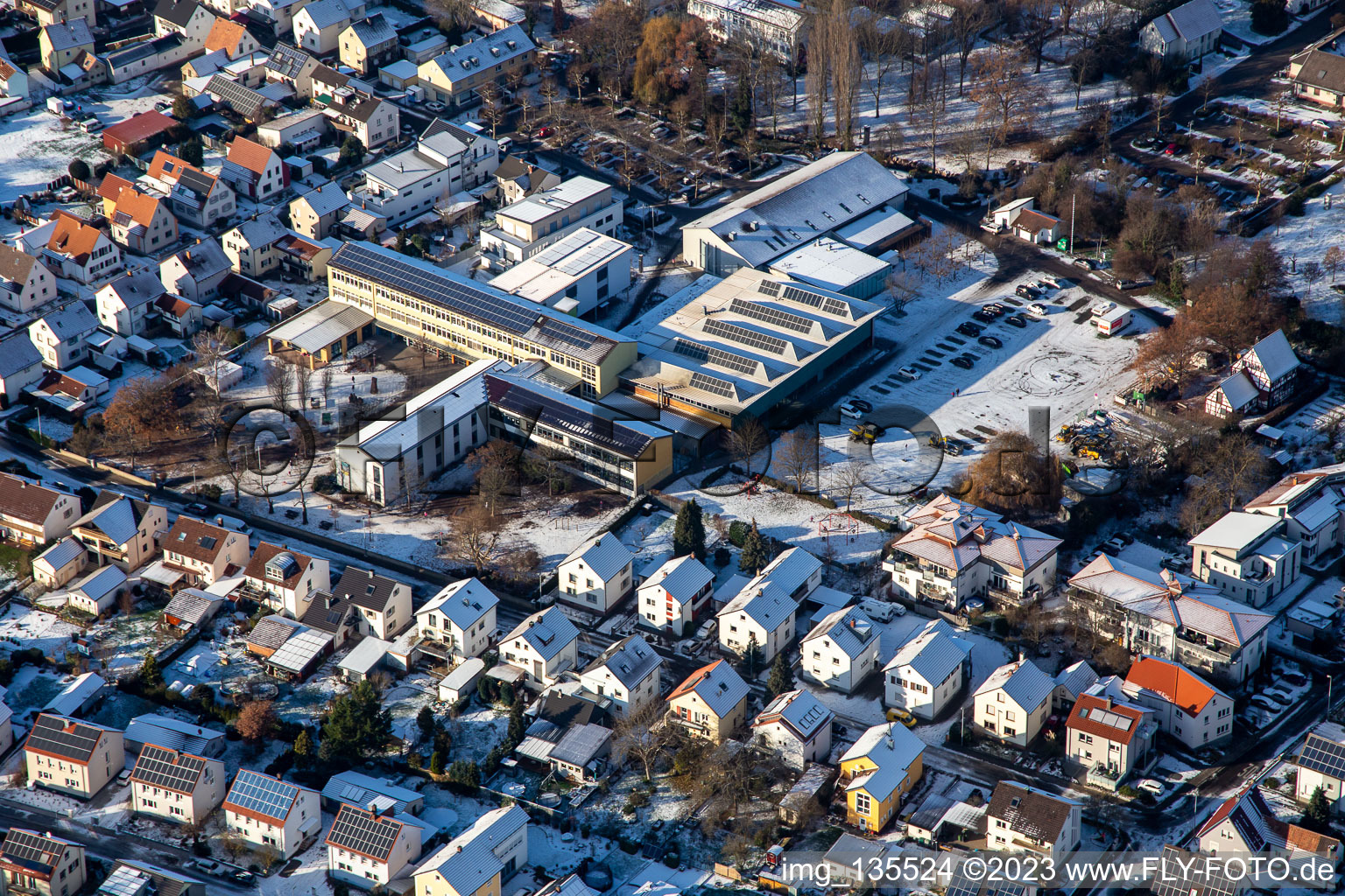 Vue aérienne de École primaire et fête foraine en hiver quand il y a de la neige à le quartier Herxheim in Herxheim bei Landau dans le département Rhénanie-Palatinat, Allemagne