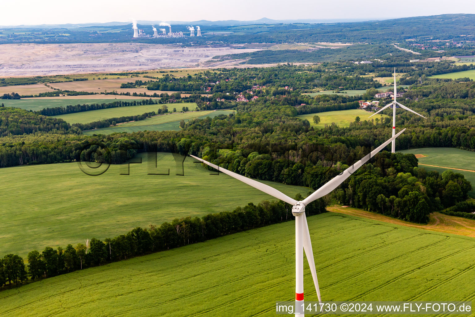 Vue aérienne de Parc éolien tchèque Wetzwalde (parc Větrný Václavice) devant la mine à ciel ouvert de lignite polonaise Kopalnia Węgla Brunatnego Turów à Hrádek nad Nisou dans le département Liberec, République tchèque