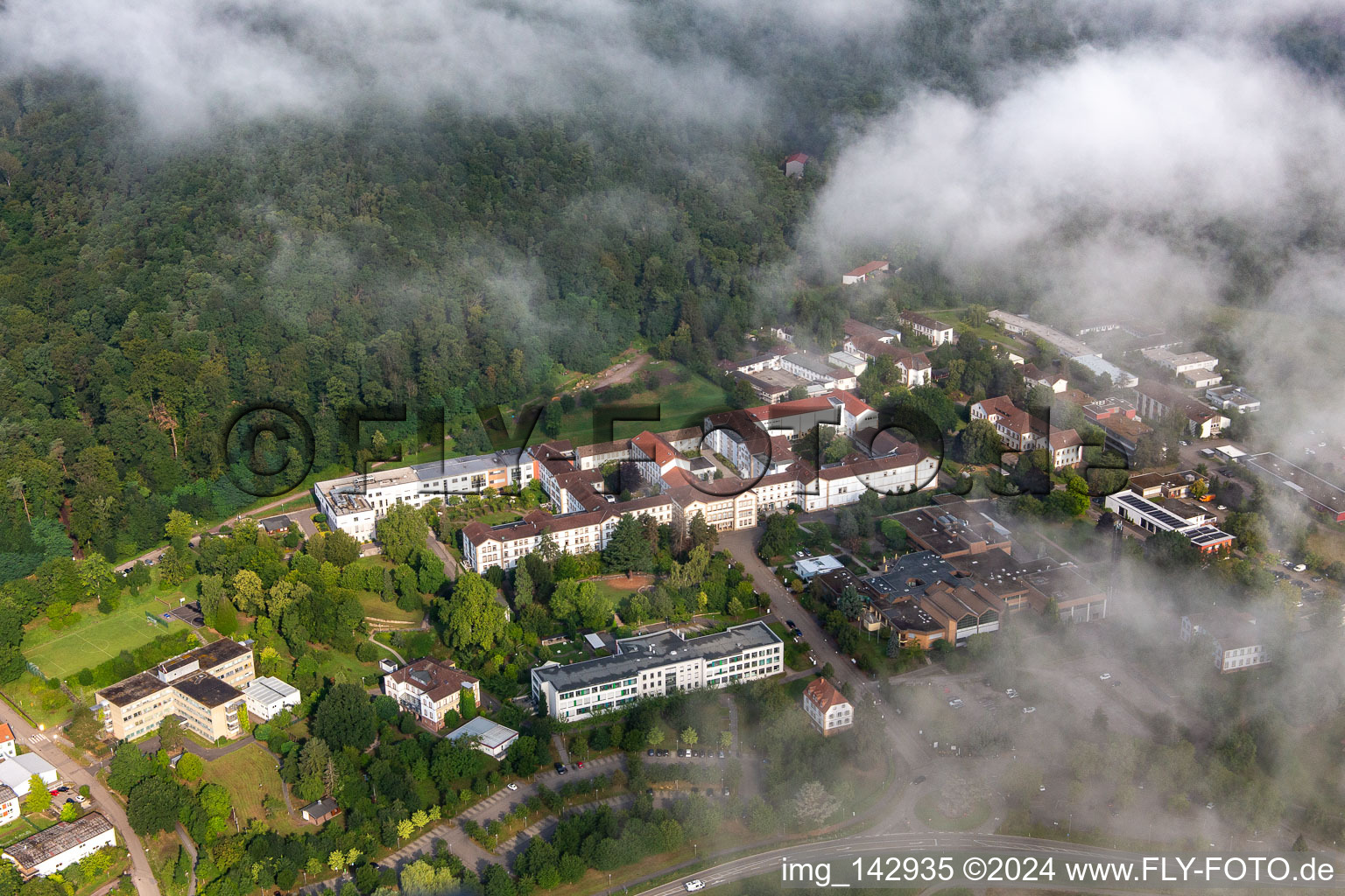 Des nuages denses au-dessus de l’hôpital palatin de psychiatrie et de neurologie à Klingenmünster dans le département Rhénanie-Palatinat, Allemagne d'en haut