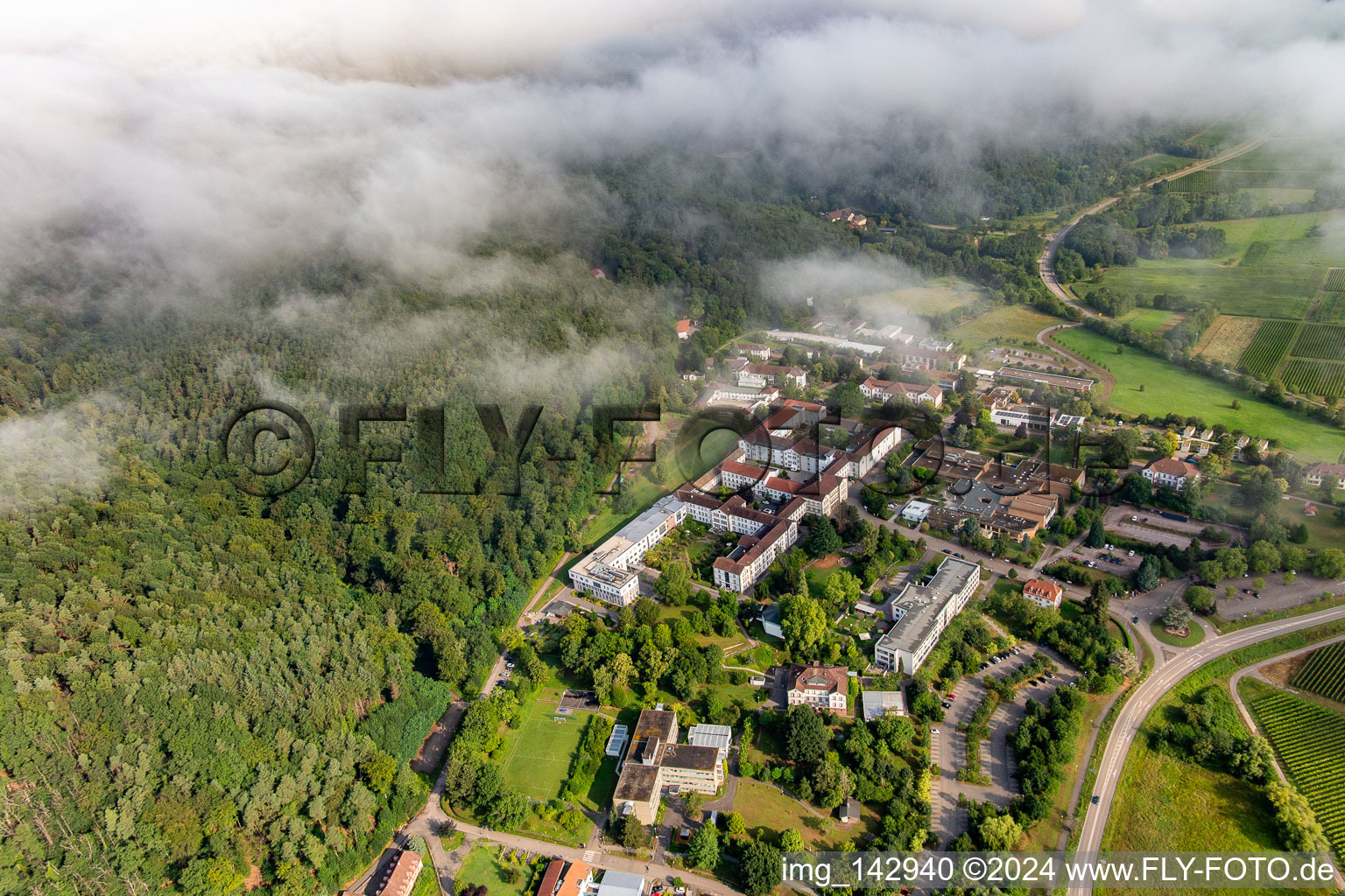 Des nuages denses au-dessus de l’hôpital palatin de psychiatrie et de neurologie à Klingenmünster dans le département Rhénanie-Palatinat, Allemagne depuis l'avion