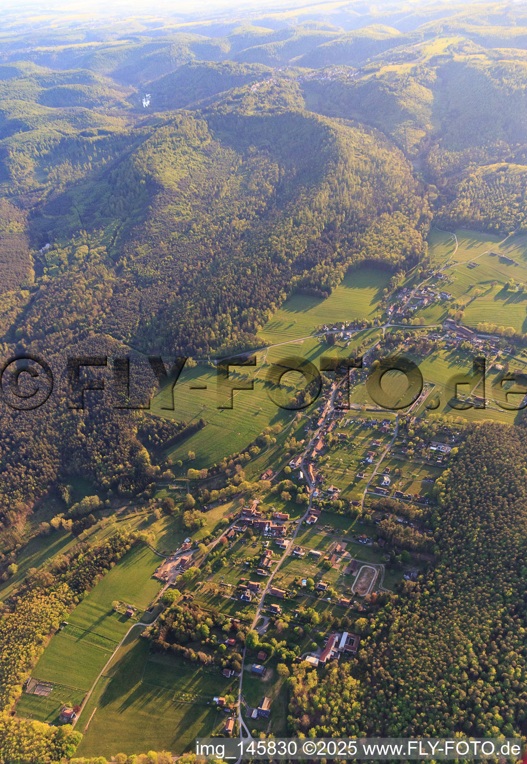 Vue aérienne de Vue d'un village dans une clairière forestière des Vosges du Nord depuis le nord-est à Erckartswiller dans le département Bas Rhin, France