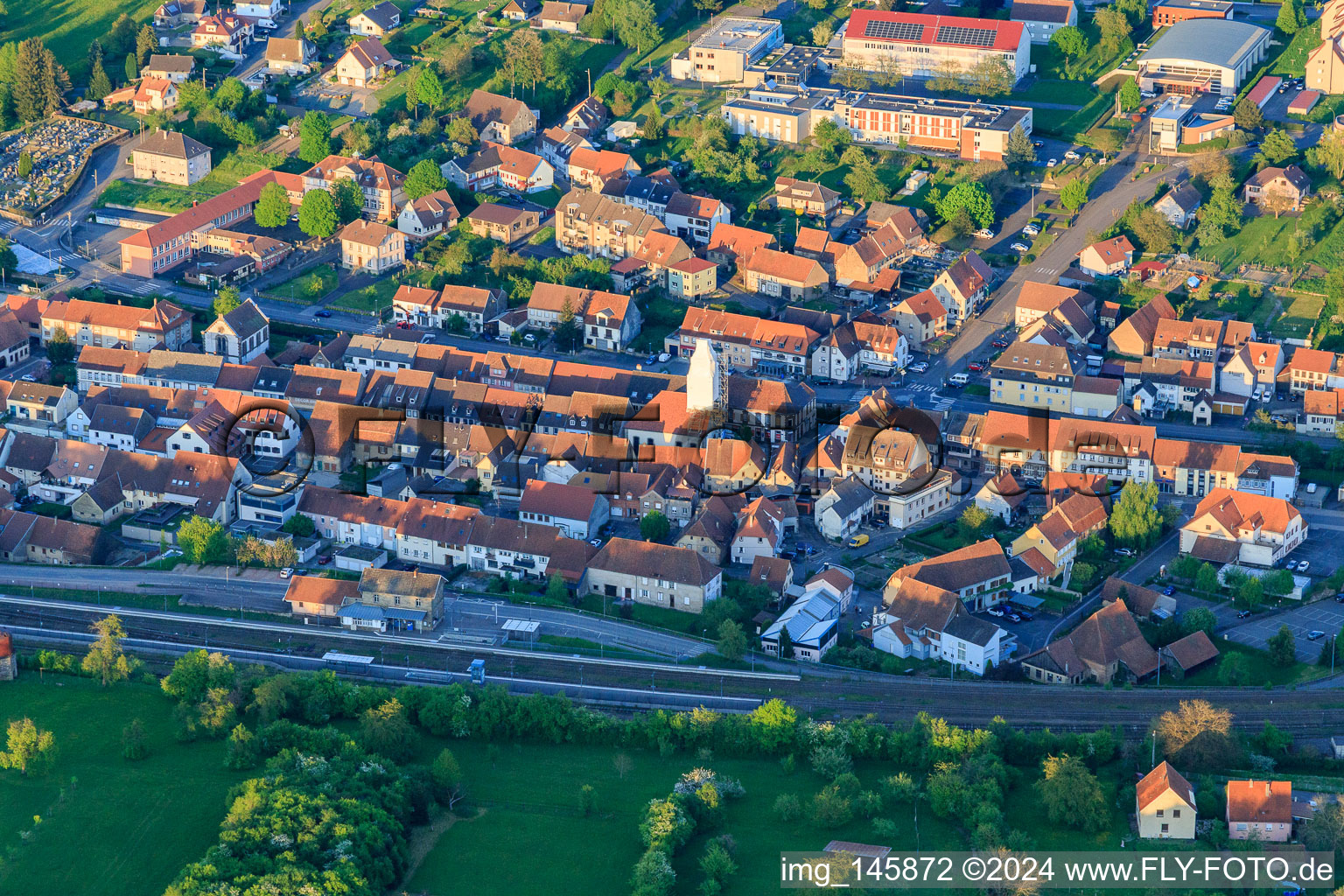 Vue aérienne de Centre-ville à la gare avec clocher échafaudé à Diemeringen dans le département Bas Rhin, France
