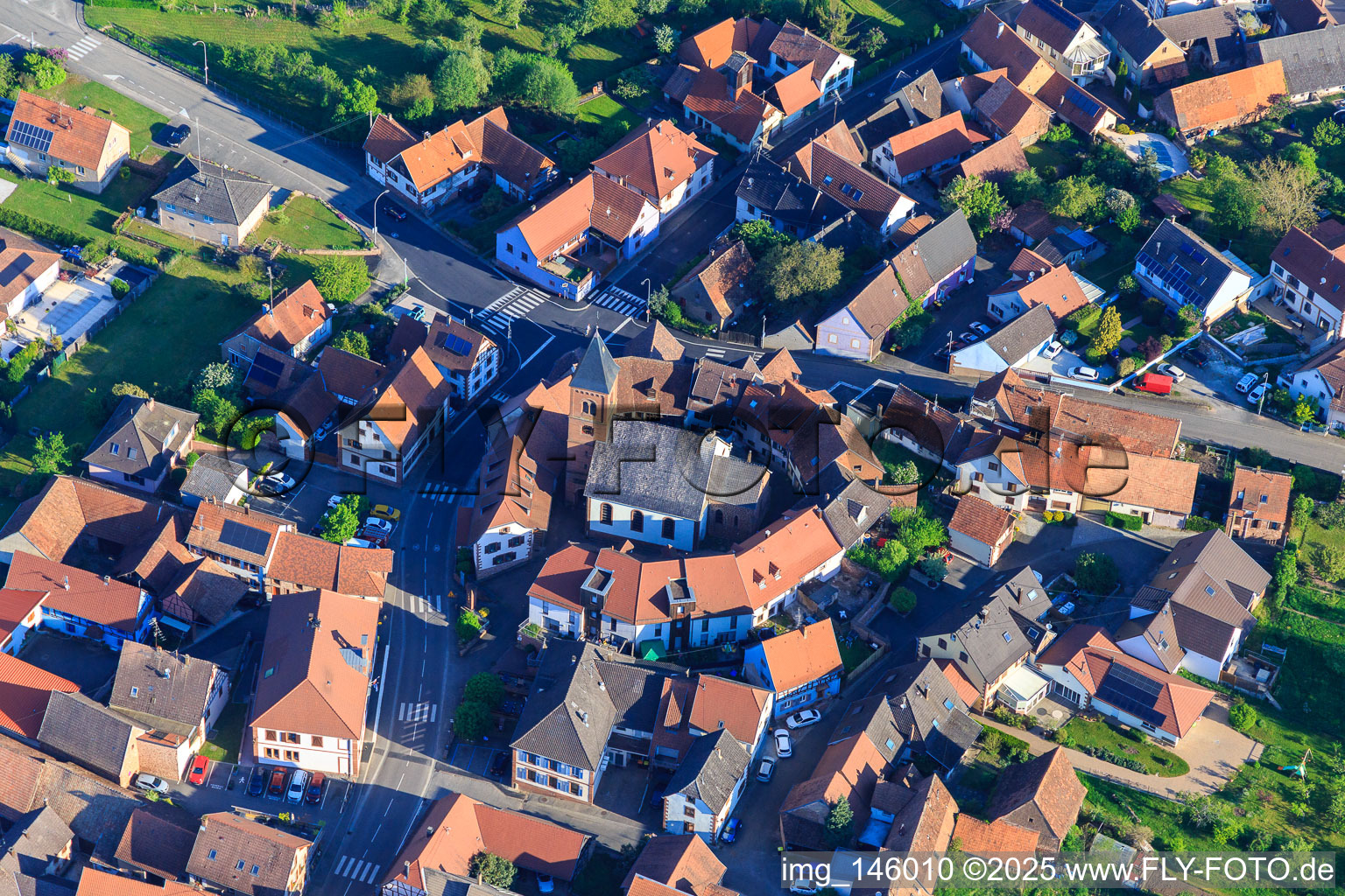 Vue aérienne de Église protestante luthérienne en tant qu'église fortifiée entourée d'un cercle de maisons à Dossenheim-sur-Zinsel dans le département Bas Rhin, France