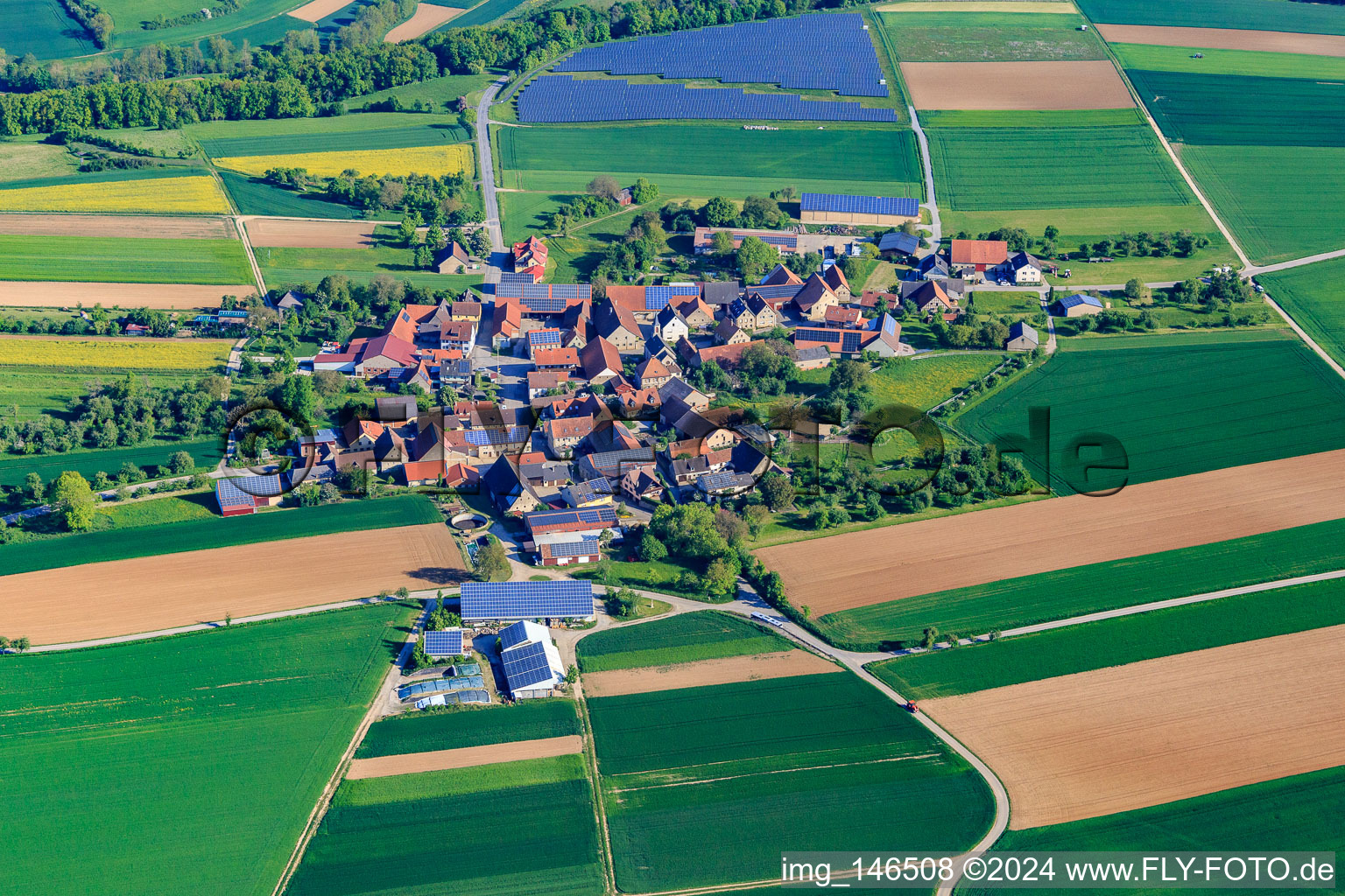 Vue aérienne de Vue d'ensemble du village le matin depuis le sud avec un champ photovoltaïque à le quartier Buch in Bieberehren dans le département Bavière, Allemagne