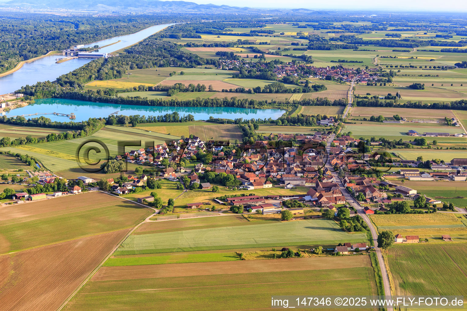 Vue aérienne de Vue du village depuis le nord devant le lac de carrière/gravière de la SAS Les Gravières Rhénanes à Friesenheim dans le département Bas Rhin, France