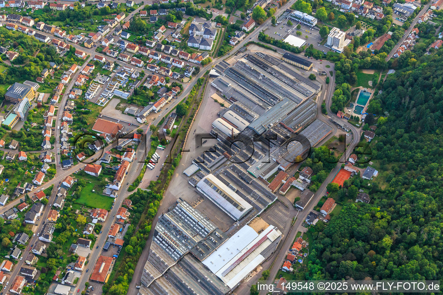 Vue aérienne de Halls industriels de Villeroy & Boch AG et piscine naturelle de Heilborn à Merzig dans le département Sarre, Allemagne
