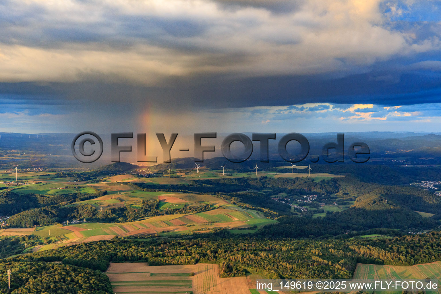 Photographie aérienne de Parc éolien Merchingen devant un mur de pluie avec arc-en-ciel à le quartier Merchingen in Merzig dans le département Sarre, Allemagne