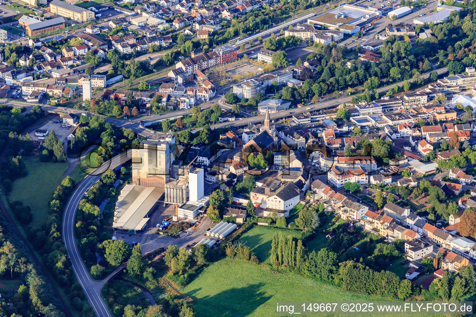 Vue aérienne de Franz Juchem GmbH, usine de Lebach et église de la Sainte-Trinité et de la Sainte-Marie à le quartier Bubach-Calmesweiler in Eppelborn dans le département Sarre, Allemagne
