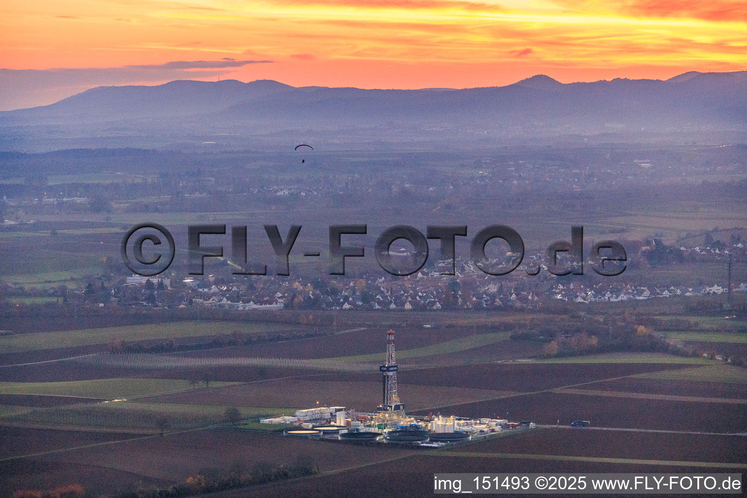 Vue aérienne de Le site de forage profond V20 de Vulcan Energy à Schleidberg, baigné par la lumière du soir, pour l'extraction d'énergie géothermique et de lithium. à Insheim dans le département Rhénanie-Palatinat, Allemagne