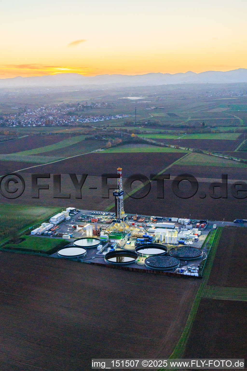 Vue aérienne de Le site de forage profond V20 de Vulcan Energy à Schleidberg, baigné par la lumière du soir, pour l'extraction d'énergie géothermique et de lithium. à Insheim dans le département Rhénanie-Palatinat, Allemagne