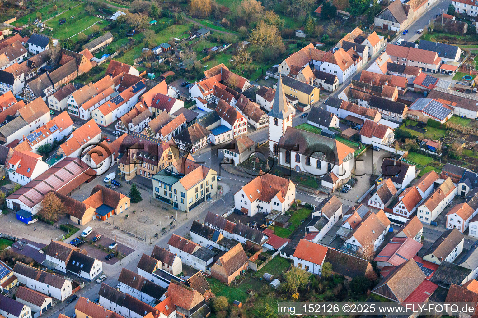Vue aérienne de Place du village avec centre communautaire et agence VR Bank Südpfalz eG d'Ottersheim, ainsi qu'une église à Ottersheim bei Landau dans le département Rhénanie-Palatinat, Allemagne