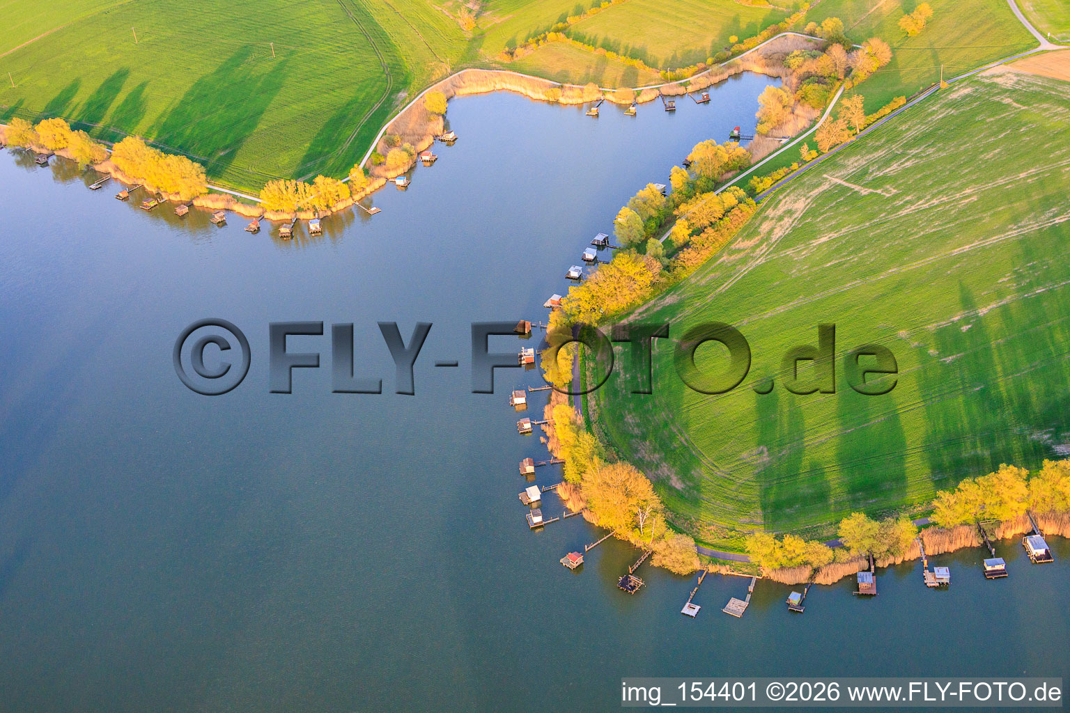 Des promenades en bois bordées de cabanes de pêcheurs longent les rives de l'étang du Welschhof. à Puttelange-aux-Lacs dans le département Moselle, France