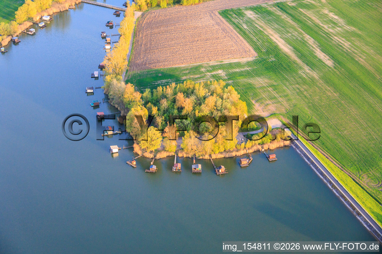 Des promenades en bois bordées de cabanes de pêcheurs longent les rives de l'étang du Welschhof. à Puttelange-aux-Lacs dans le département Moselle, France