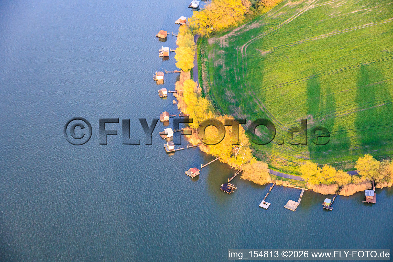 Des promenades en bois bordées de cabanes de pêcheurs longent les rives de l'étang du Welschhof. à Puttelange-aux-Lacs dans le département Moselle, France