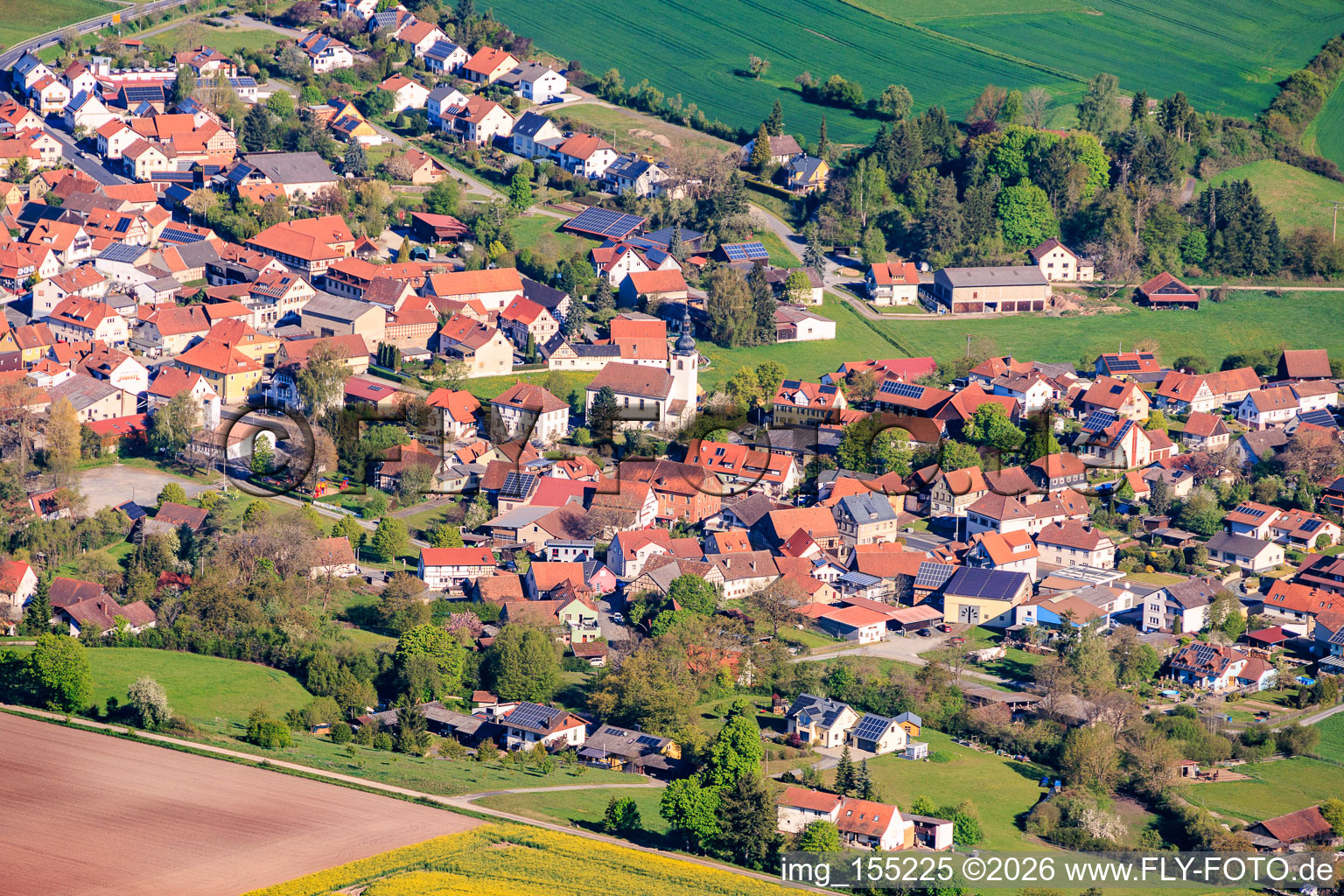 Vue du village depuis le sud-est, avec l'église évangélique luthérienne Saint-Pierre et la mairie. à Ermershausen dans le département Bavière, Allemagne