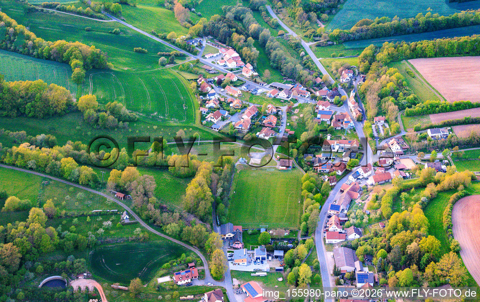 Vue du village depuis le sud-est avec le terrain de sport de SC Lußberg-Rudendorf à le quartier Lußberg in Breitbrunn dans le département Bavière, Allemagne