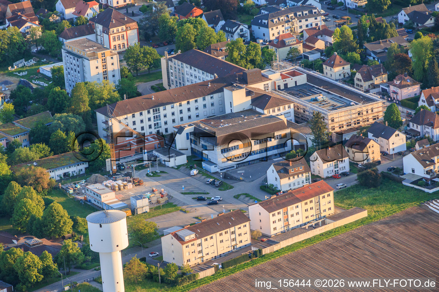 Château d'eau et chantier de construction du nouveau service d'urgence, de l'unité de soins intensifs et du service de diagnostic d'Asklepios Südpfalzkliniken GmbH. Gestion de projet : BPM Bau- und Projektmanagement Hart GmbH. Architecture, planification et surveillance du chantier : alsh sander hofrichter architekten GmbH, Gesellschaft für Architektur und Generalplanung. Planungsbüro Noll GmbH, MEP planification/chauffage, ventilation, plomberie, gaz médicaux et immotique ; Planification MEP / installations électriques haute et basse tension / technique de transport : DE-Plan GmbH & Co. KG ; ingénierie de construction : ZPP Ingenieure AG ; architecture paysagère : hofmann_röttgen Landschaftsarchitekten BDLA ; protection incendie : Rieser-Wessel Brandschutzsachverständige & Ingenieure PartG mbB ; et physique du bâtiment / isolation phonique et acoustique : Ingenieurbüro Seidel. à Kandel dans le département Rhénanie-Palatinat, Allemagne