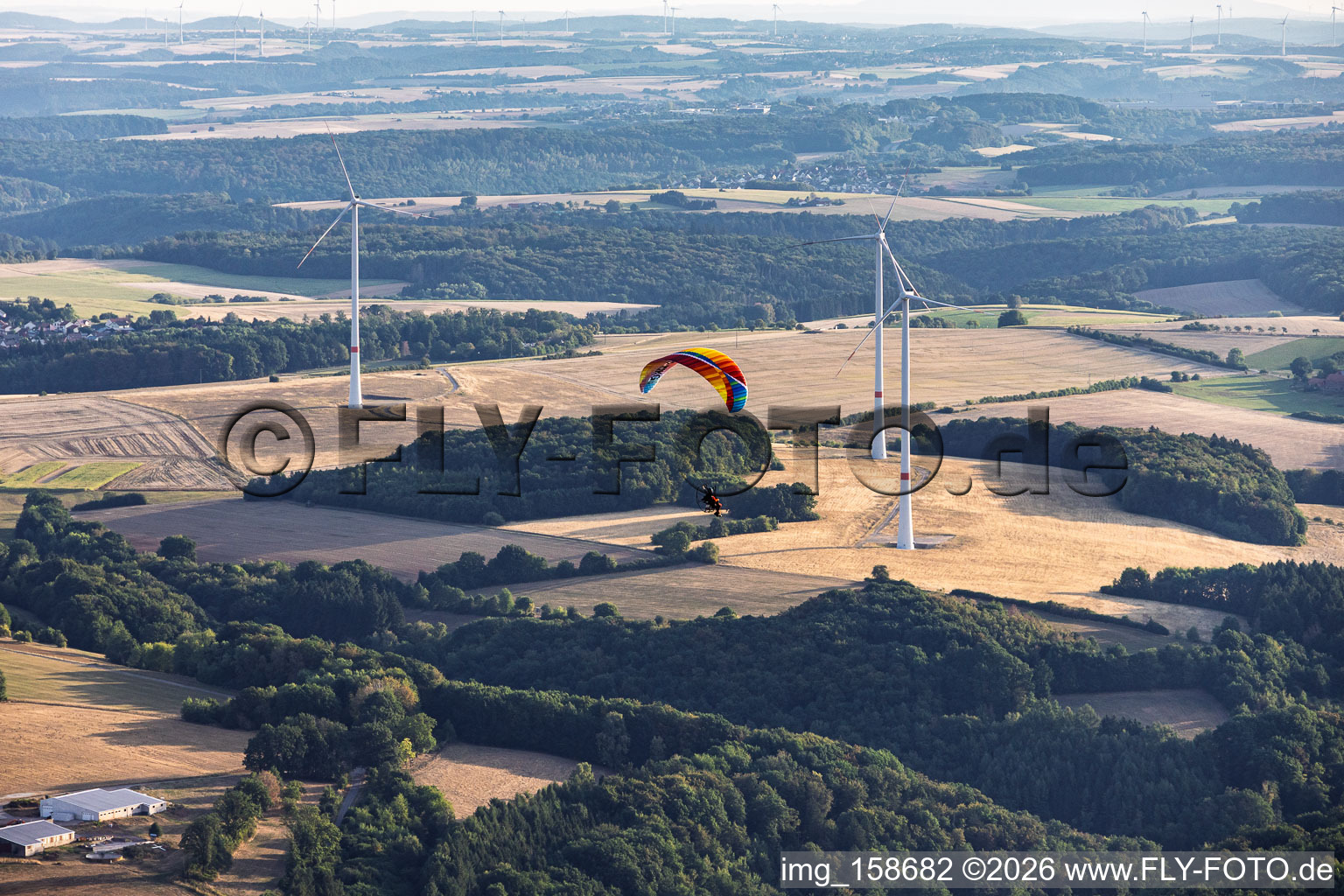 Parapente devant le parc éolien d'Einöderwiesenhof à Riedelberg dans le département Rhénanie-Palatinat, Allemagne